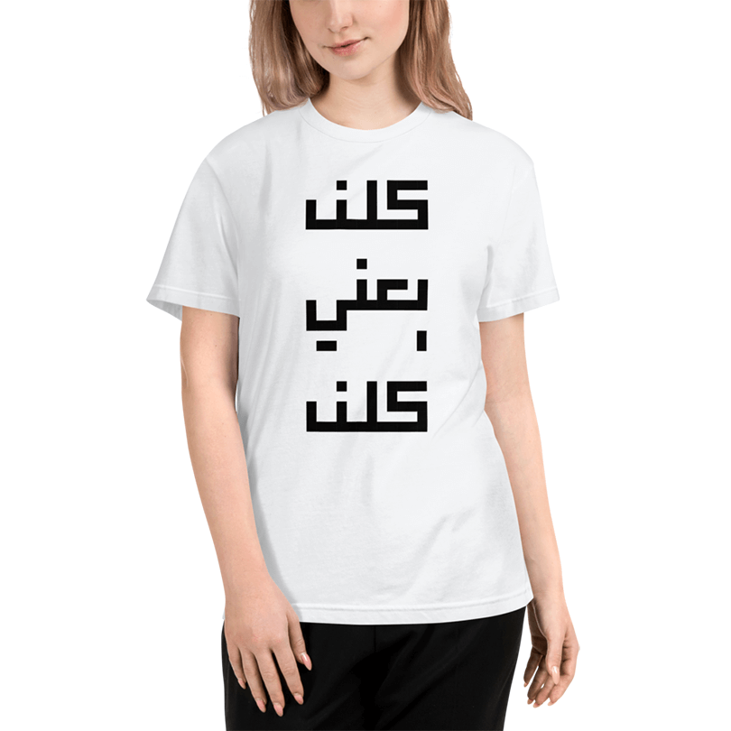 A white t-shirt with a designed Arabic text saying 'All of them means all of them' in monotone, a popular chant during the protests.